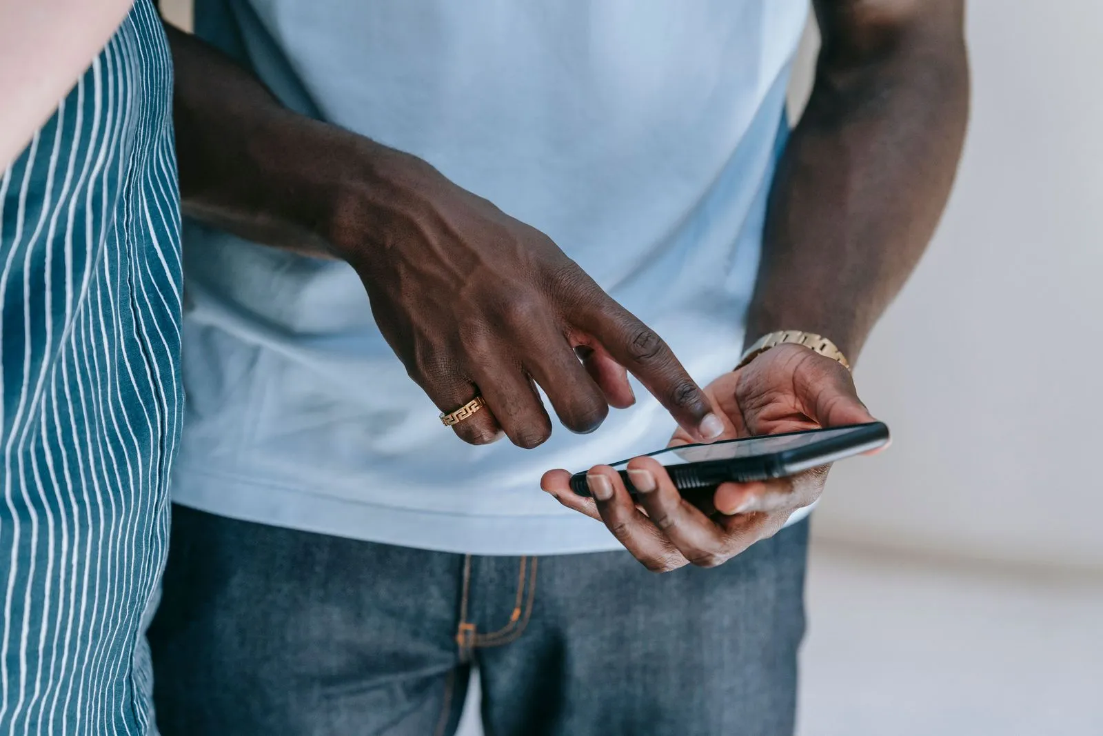 Primo piano di due mani che toccano lo schermo di uno smartphone