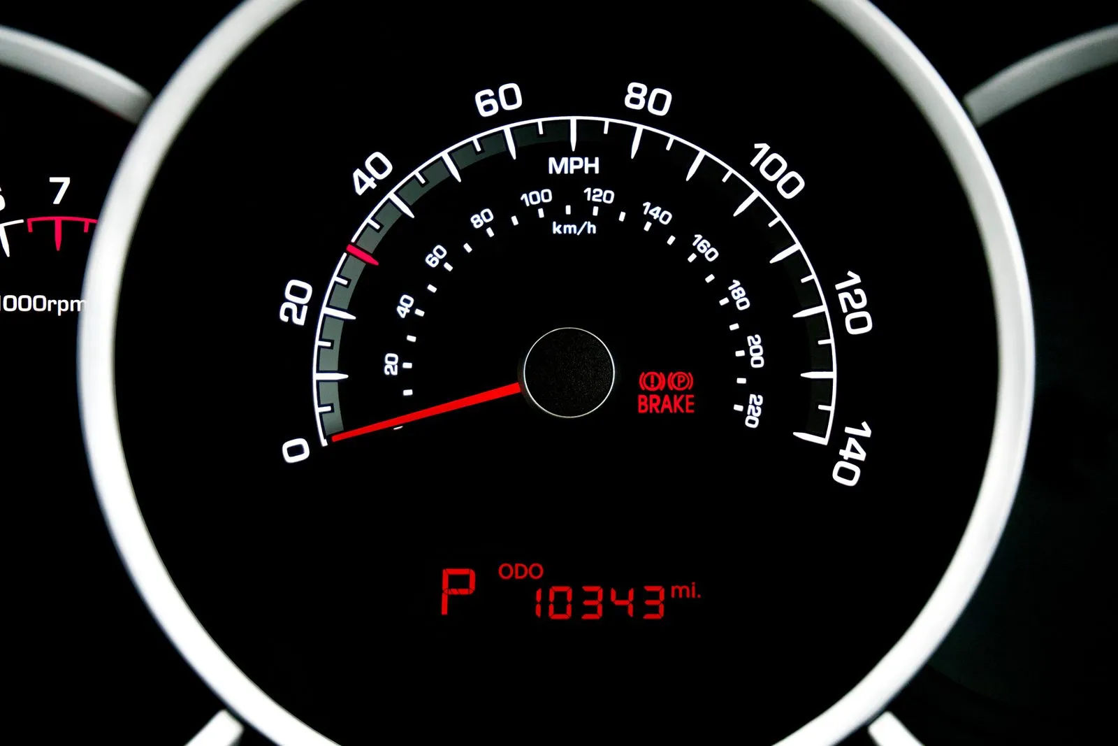 A car instrument cluster with an MPH speedometer and a digital odometer reading in miles